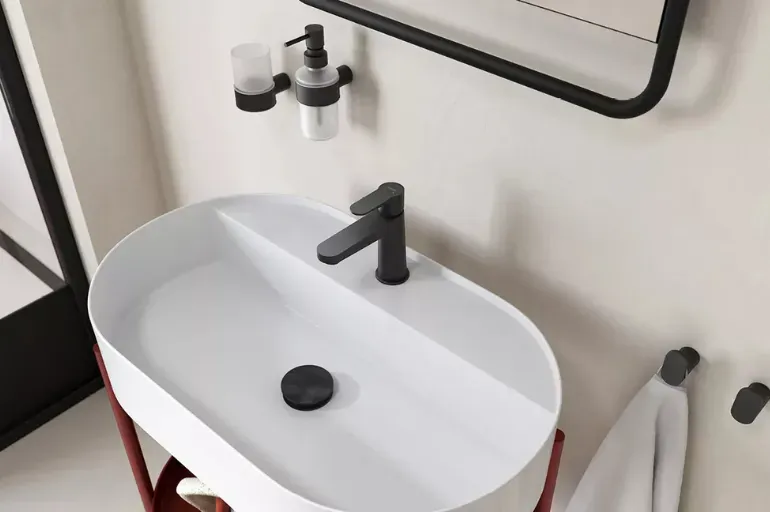 Minimalistyczna łazienka z czarną armaturą FERRO NOSTRIS, dozownikiem, szklanką i wieszakami